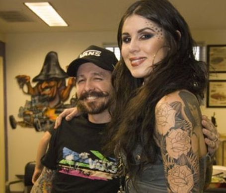 oliver and Kat in their tattoo studio, kat hugging oliver 